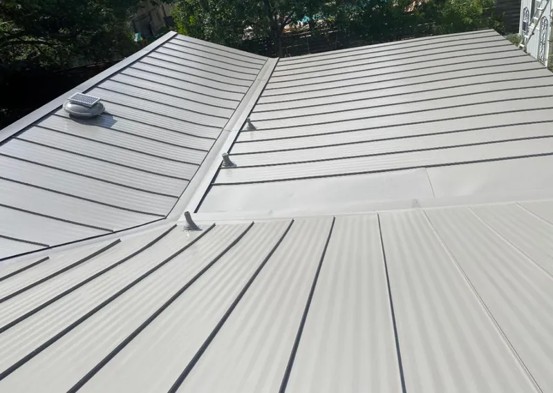 Solar attic fan installed on a metal roof for Roof Ventilation in Malverne